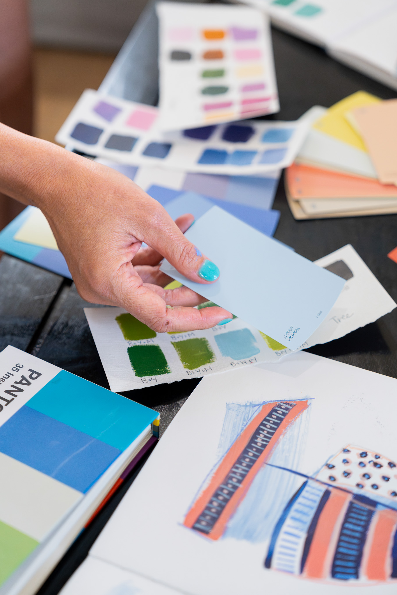 Shelby Dillon holds color swatches for the camera to see among a slew of inspiration within the frame.