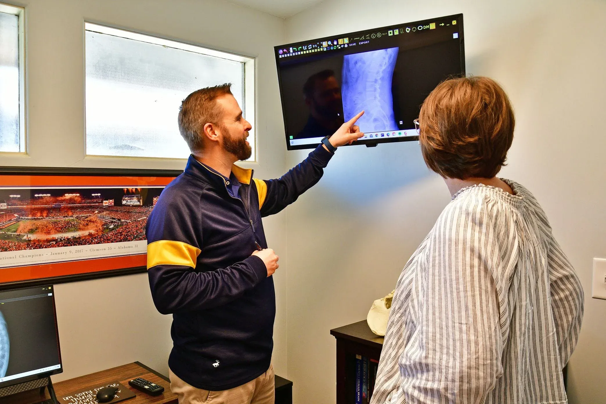 chiropractor looking at x-rays with patient