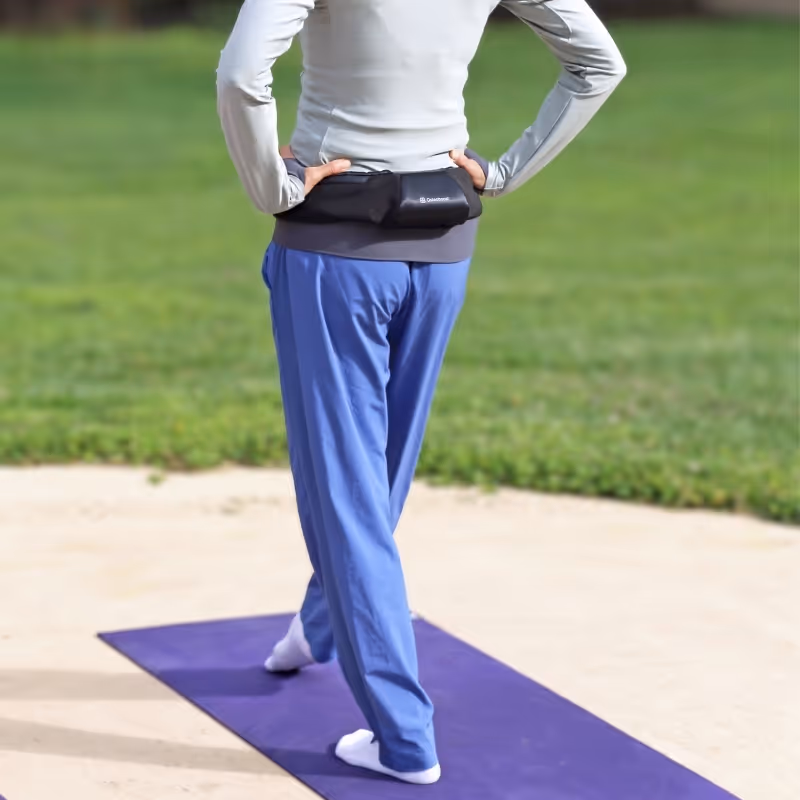 Woman exercising outdoors while wearing her Osteoboost device