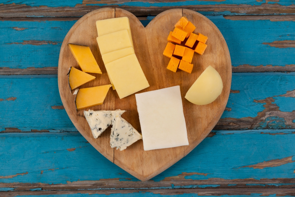 Variety of cheese on heart shaped chopping board