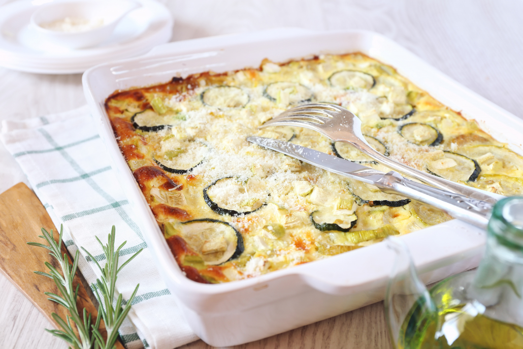 Zucchini gratin with parmesan cheese and olive oil, rosemary garnish