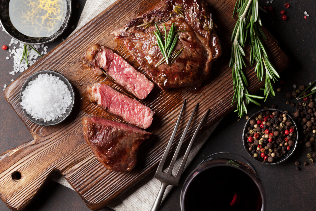 Grilled ribeye beef steak with red wine, herbs and spices. Top view