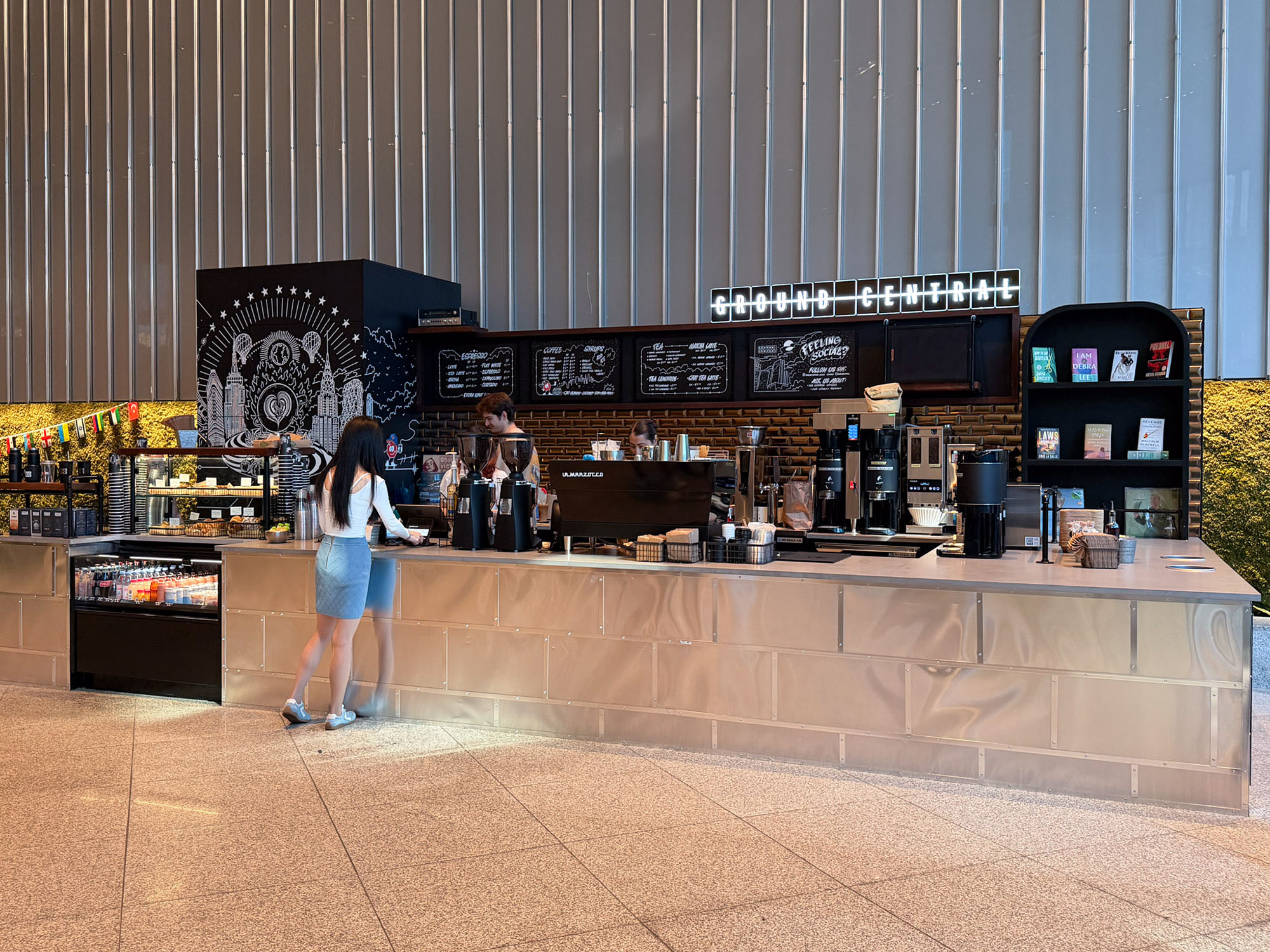 Coffee kiosk with book library and New York City artwork by Heesco at Ground Central Park Avenue Plaza