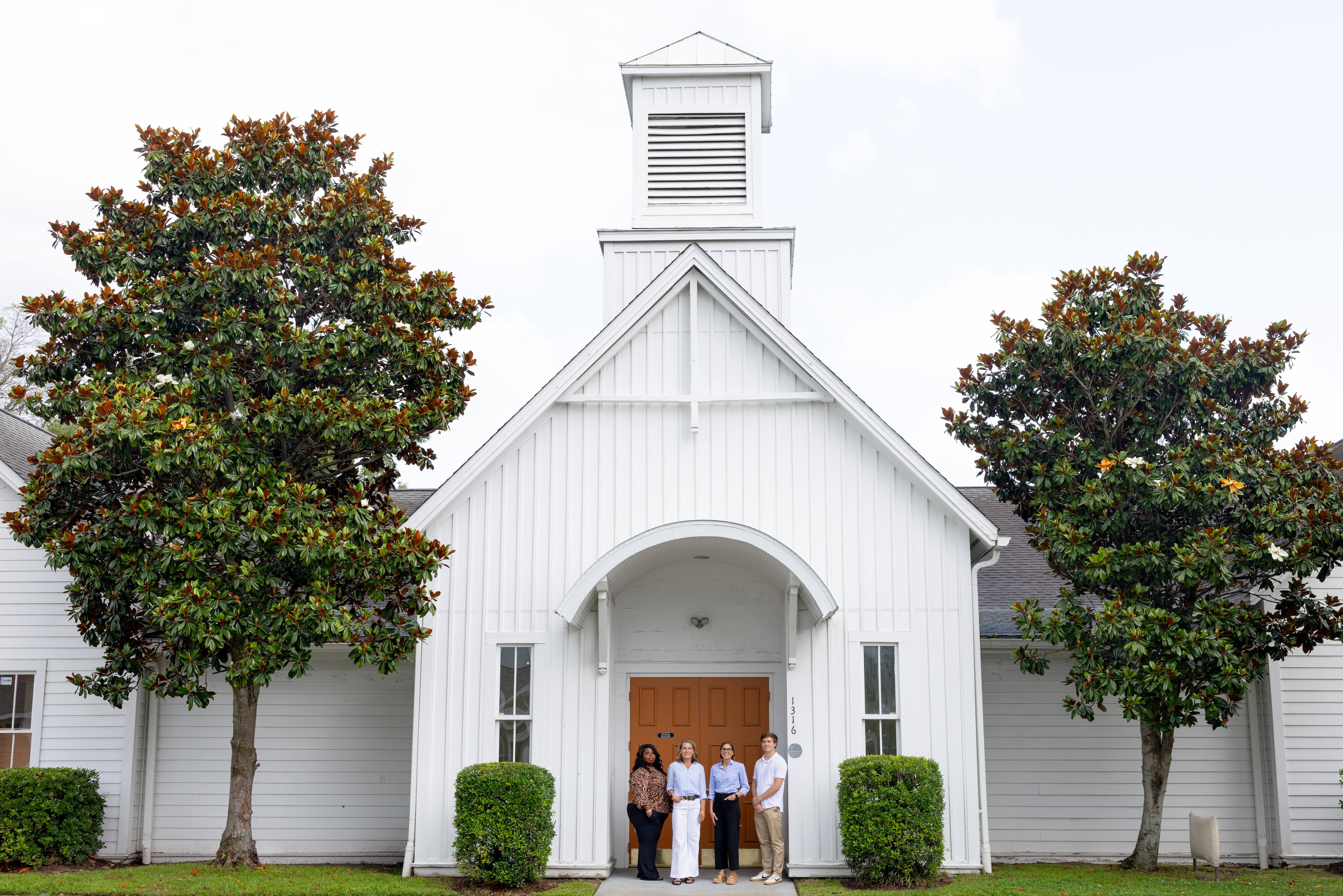 Dr. Suzanne Kerns and Robin Secrist stand together in a field of tall grass, smiling and engaged in conversation.