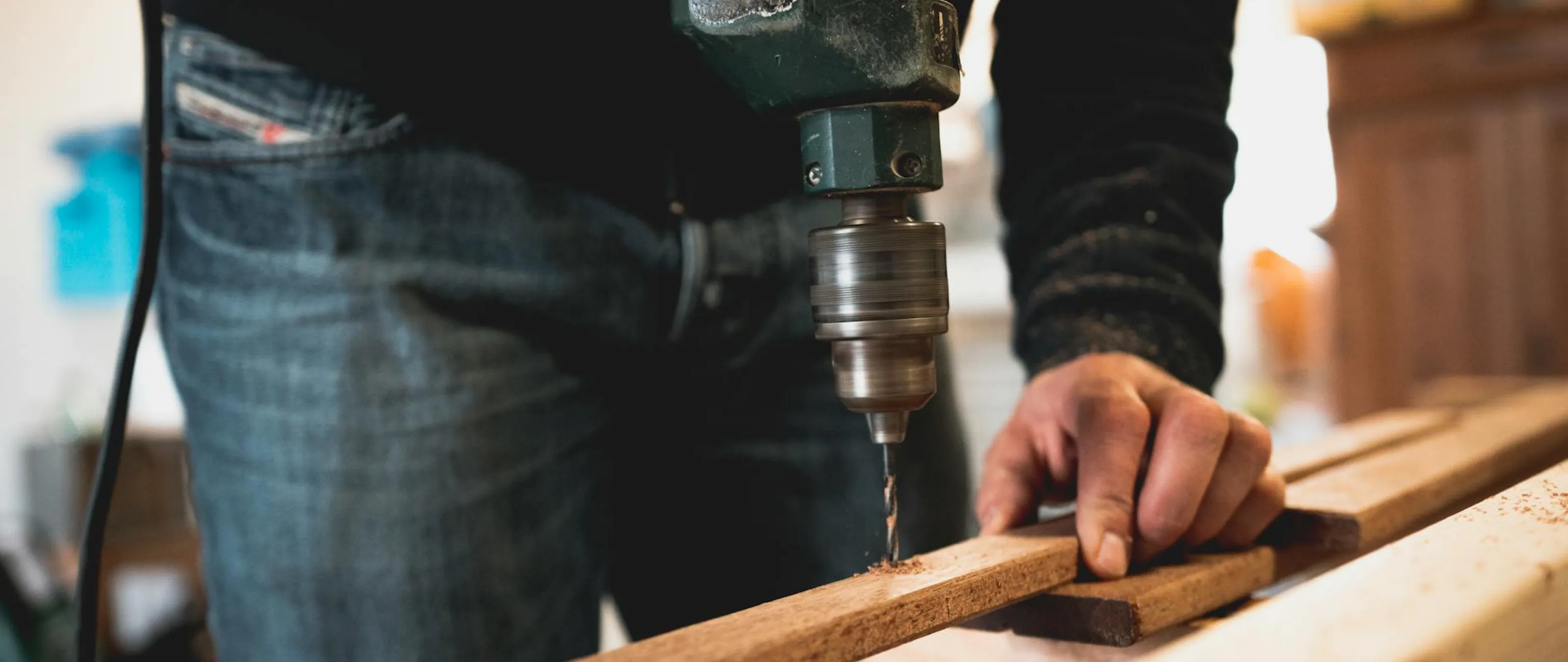 A carpenter drilling into a piece of wood