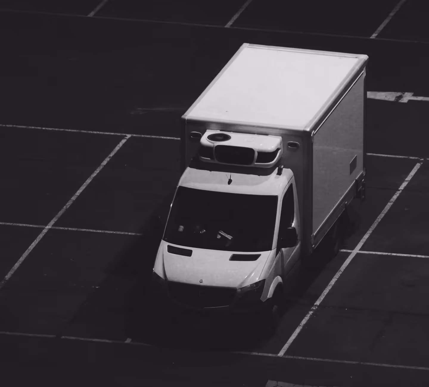 Black and white image of Luton delivery van in car park