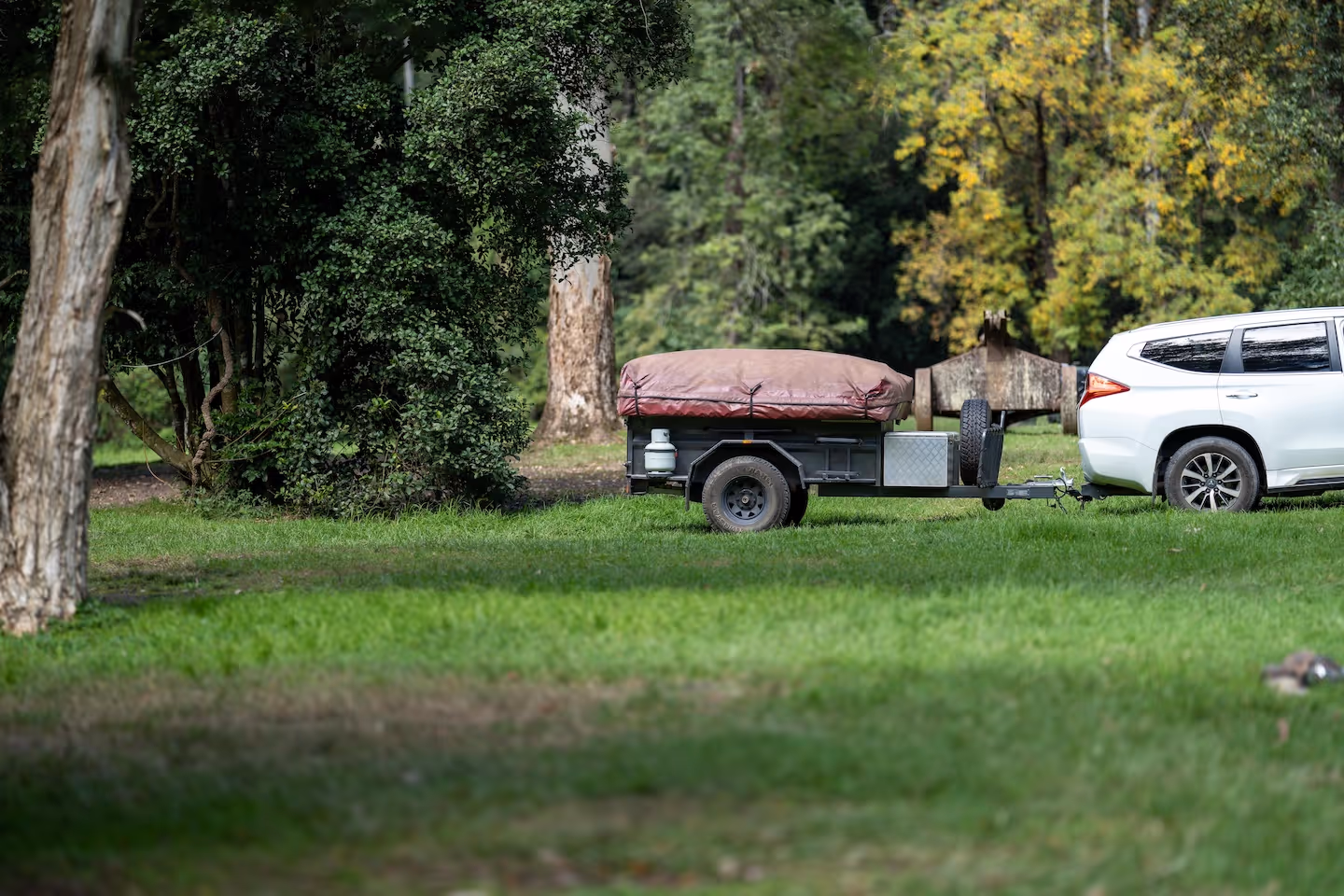 Car backing up camping trailer in England