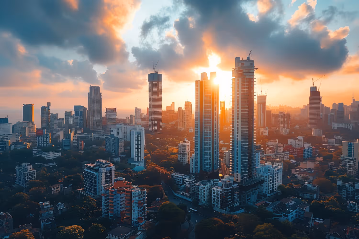 City skyline at sunset with tall skyscrapers and orange clouds in the sky.