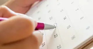Stift trägt Termin in Kalender ein