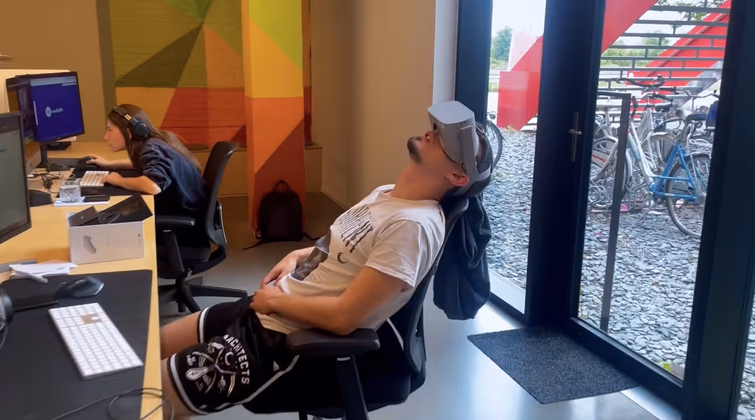 Een man zit achterover in een stoel en draagt een virtual reality-bril.