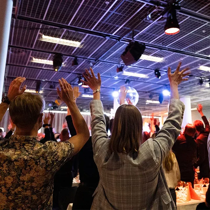 a group of people raising their hands in the air