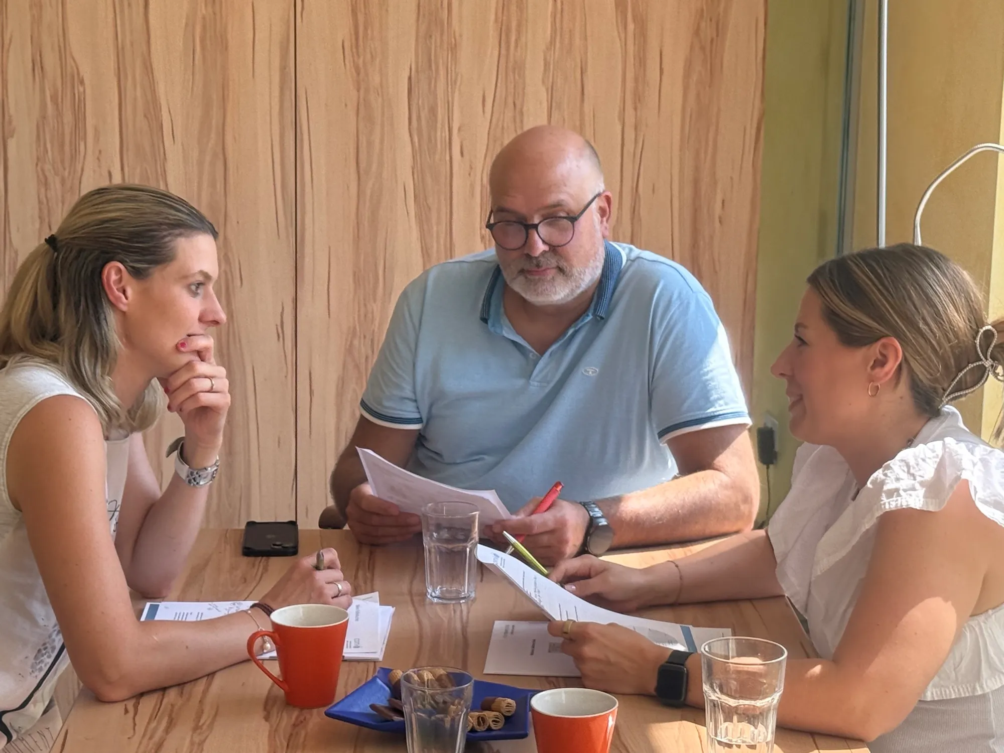 Drei Teilnehmende arbeiten am Tisch