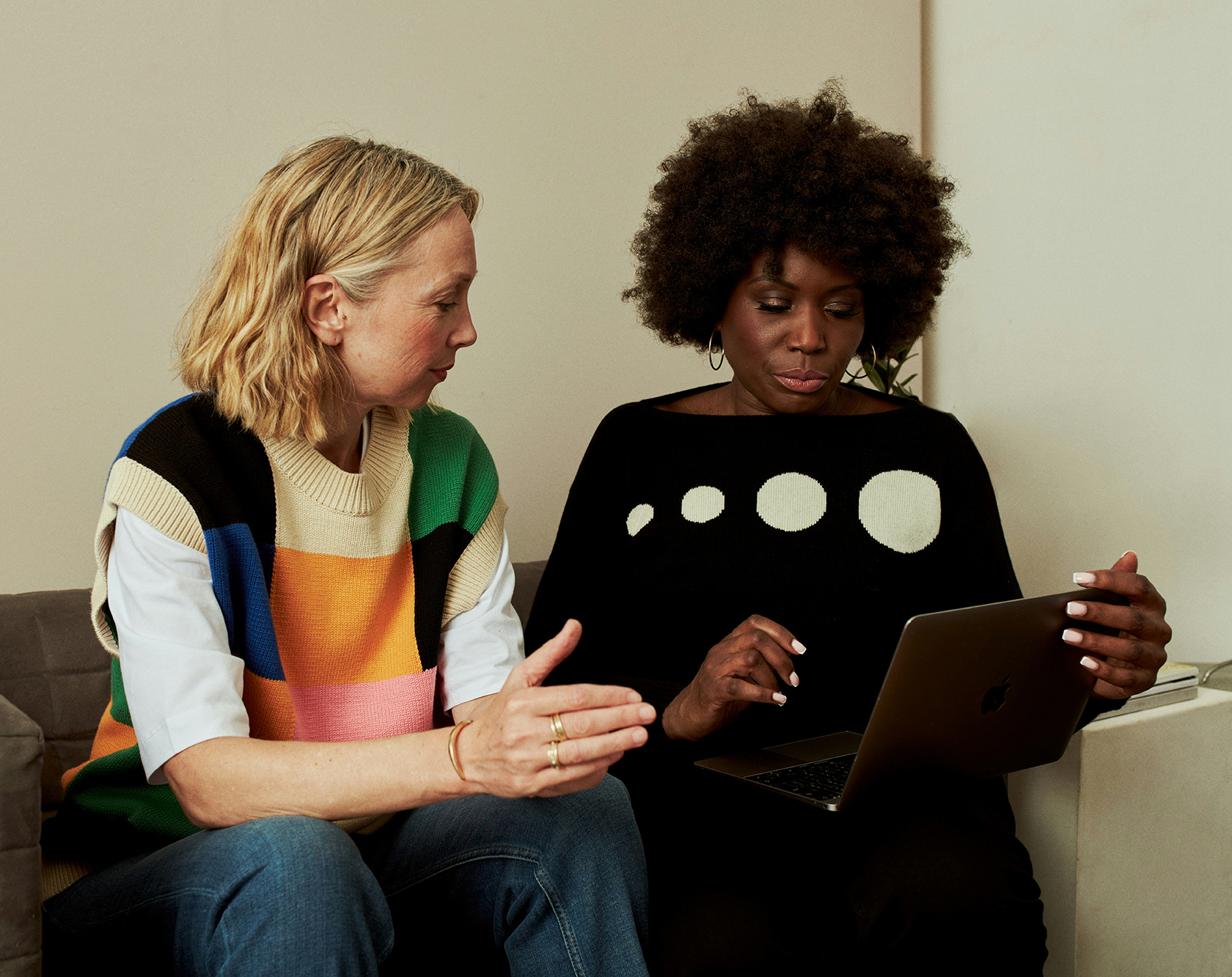 Two women having a friendly conversation in a modern office.
