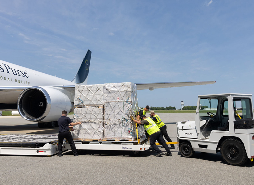 Workers load a pallet of relief supplies onto a Samaritan's Purse cargo plane.