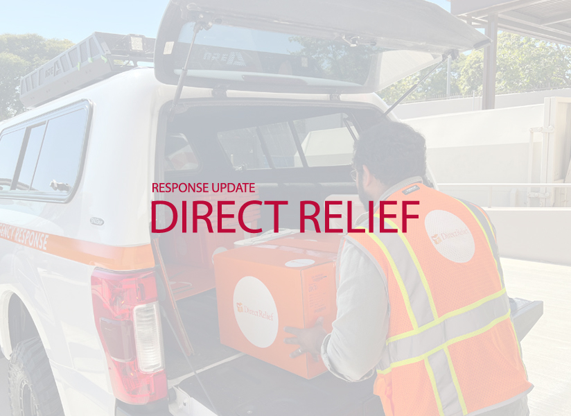 A worker in a safety vest loads a Direct Relief box into a truck, beneath the words "Response Update: Direct Relief."