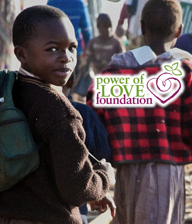 A schoolboy with a backpack looks back over his shoulder as children walk by, beside the Power of Love Foundation logo.