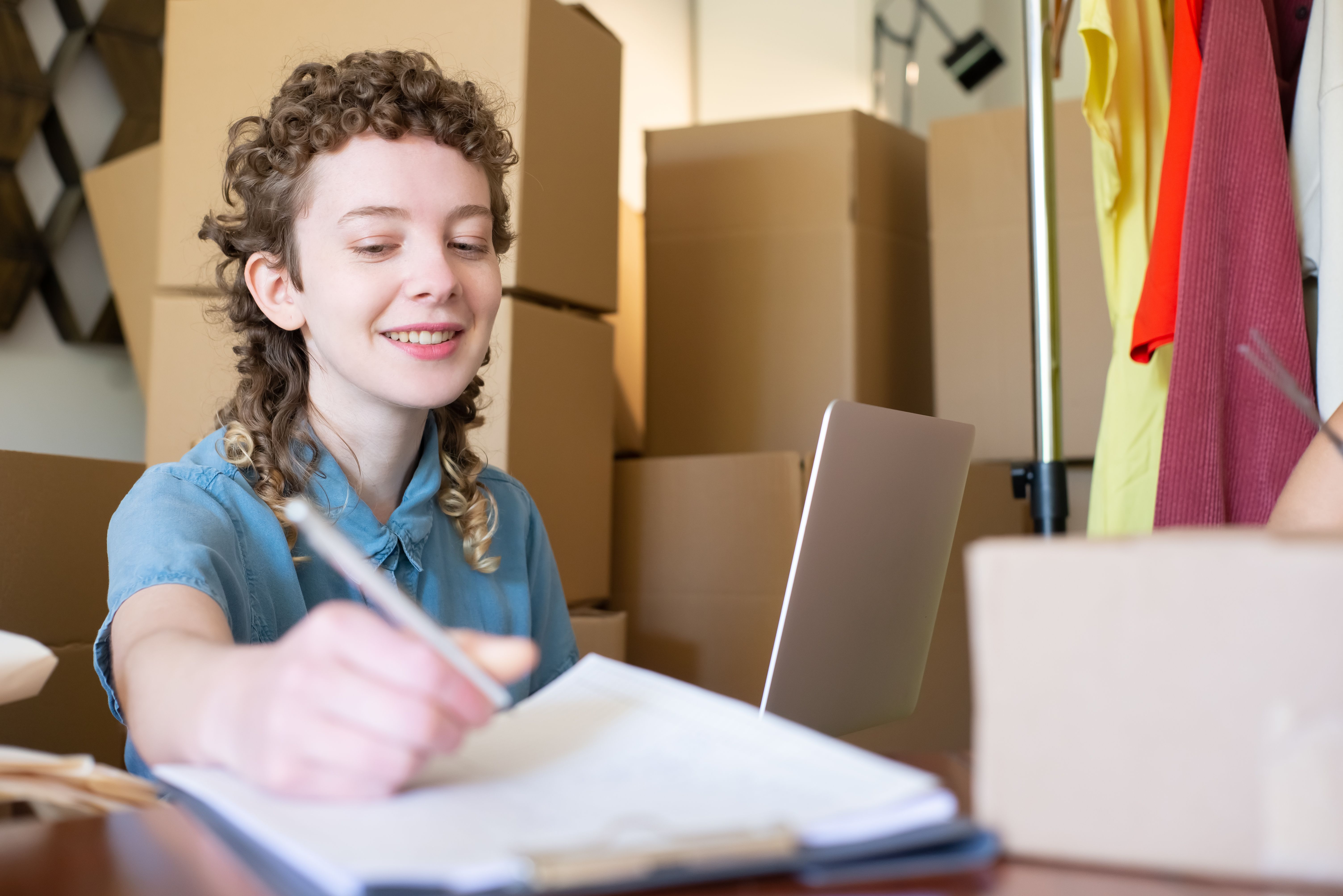 Ecommerce operator planning orders beside a laptop and parcels
