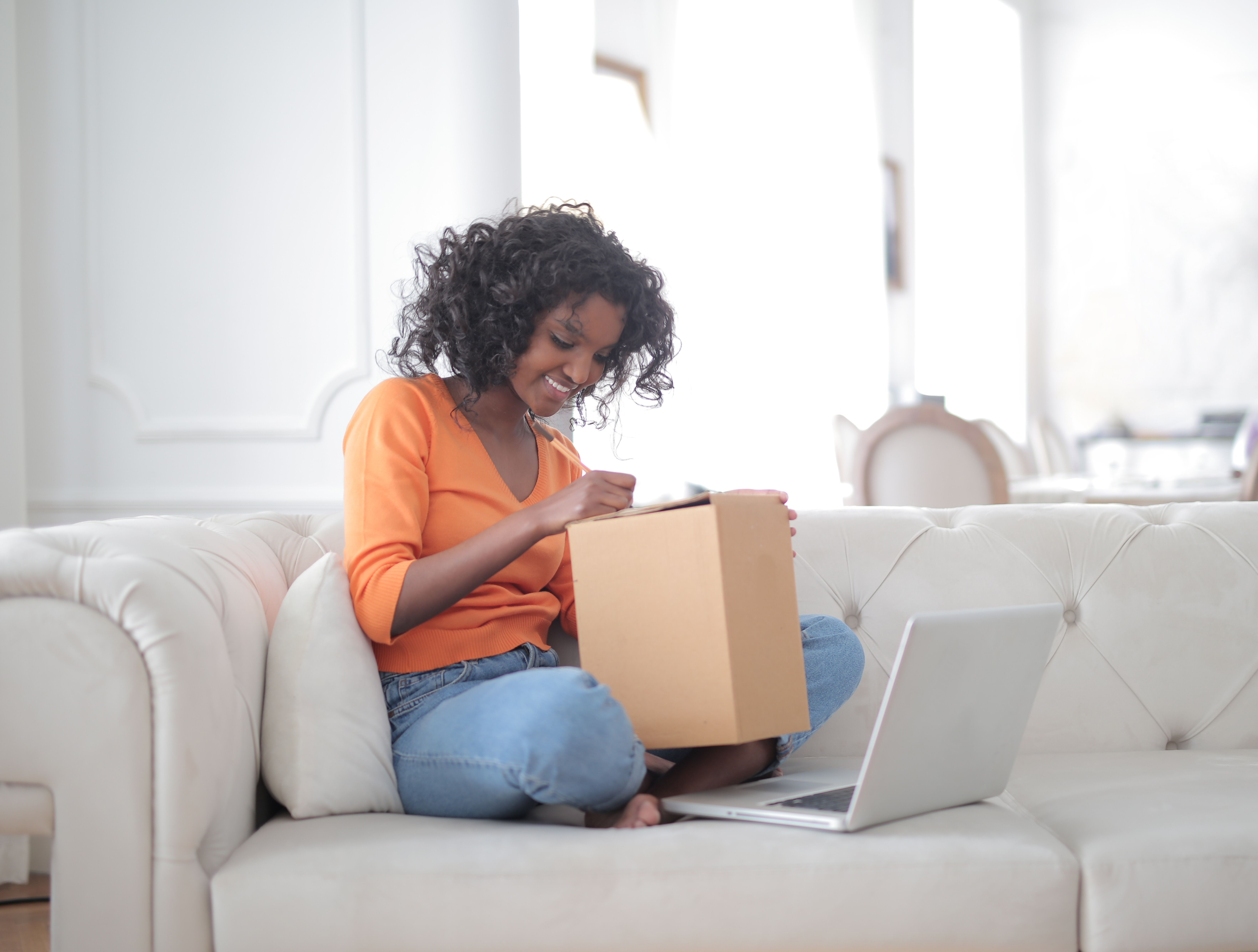 Customer opening a delivery beside a laptop