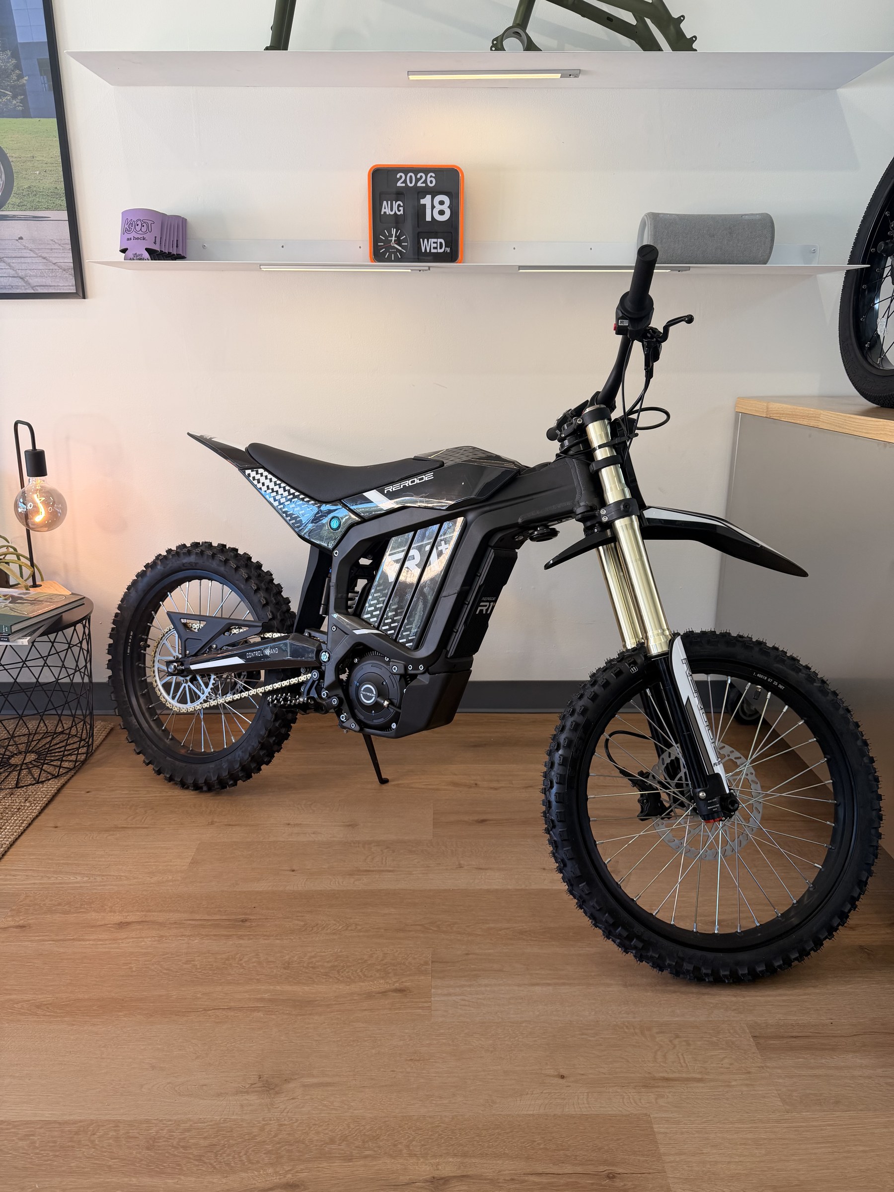 Rerode R1+ electric dirt bike, drive side profile in black and white with gold inverted forks