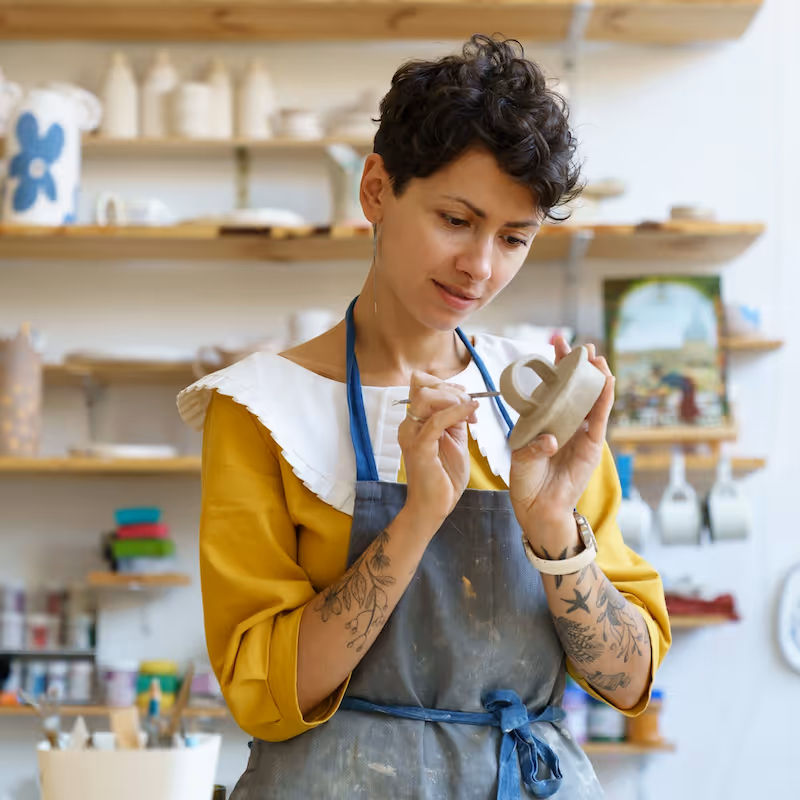 A woman painting on ceramics