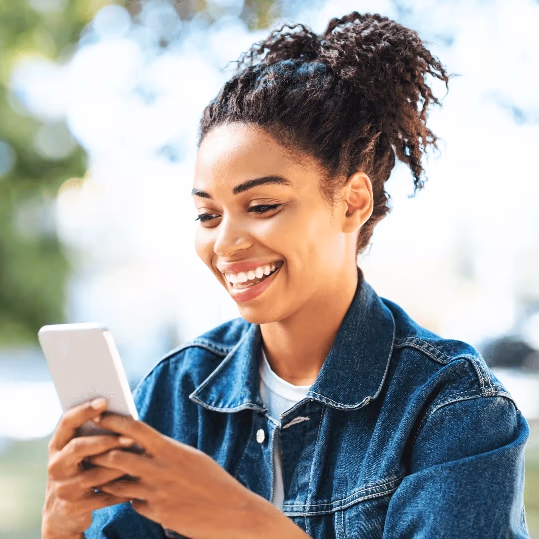 A smiling woman at her phone