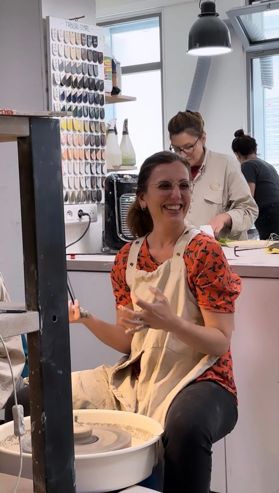 A smiling woman learning pottery