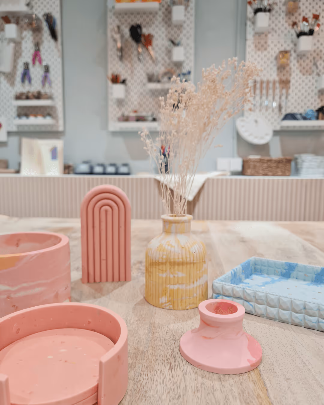 Intérieur de Mazette, un laboratoire créatif à Paris, avec des participants customisant des vêtements et confectionnant des bougies parfumées.