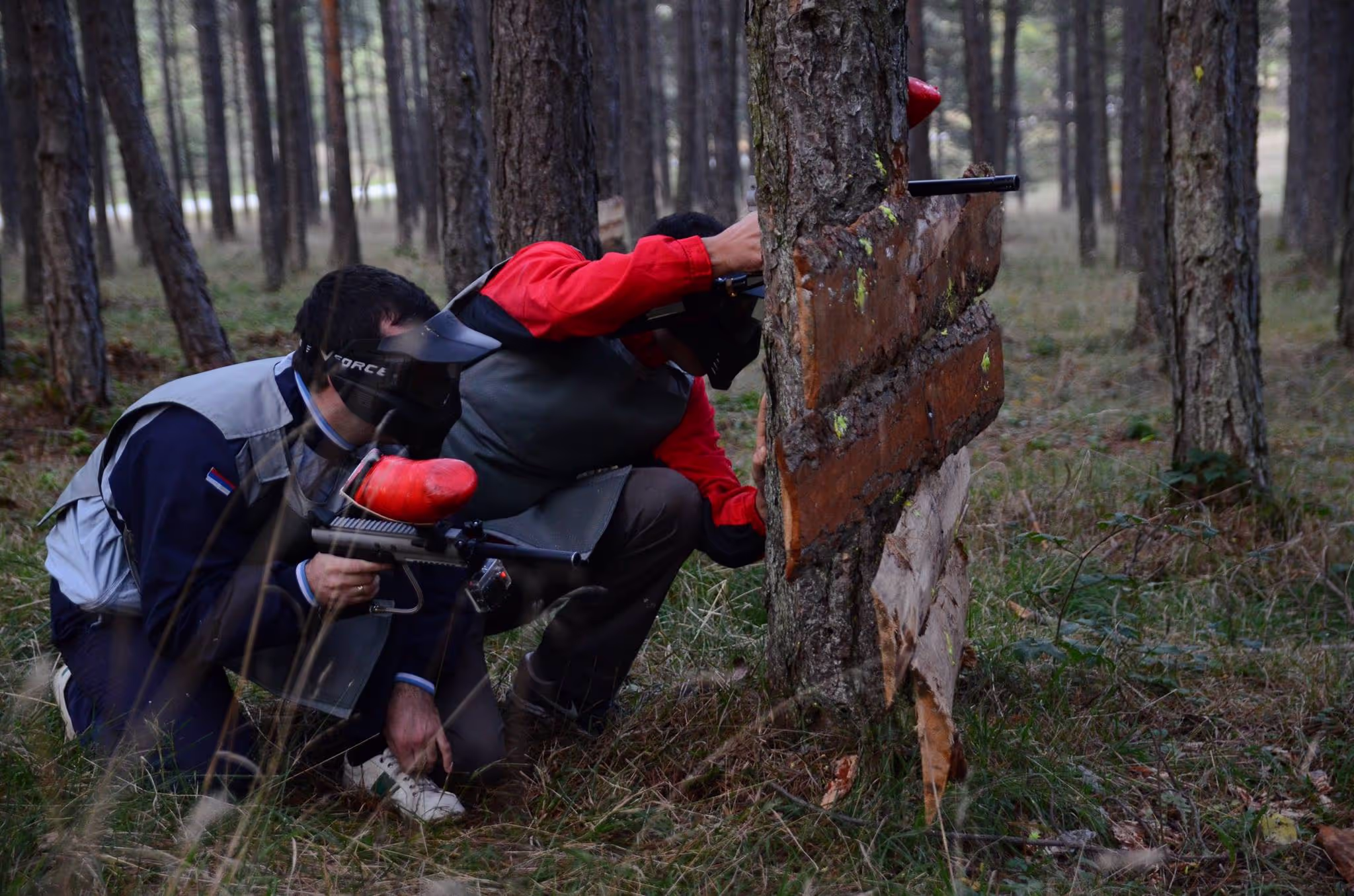 Dva prijatelja se kriju i pripremaju napad na protivnika u toku paintball runde.