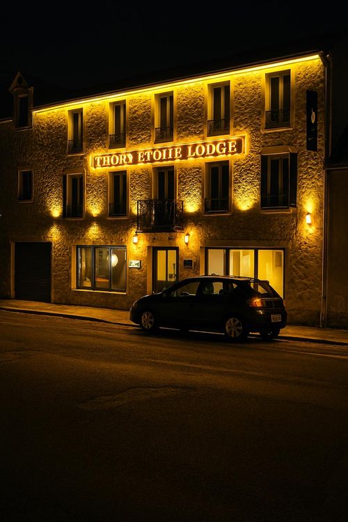 Table de réception avec de la vaisselle blanche et dorée ainsi qu'une orchidée blanche dans la salle de séminaire et célébrations
