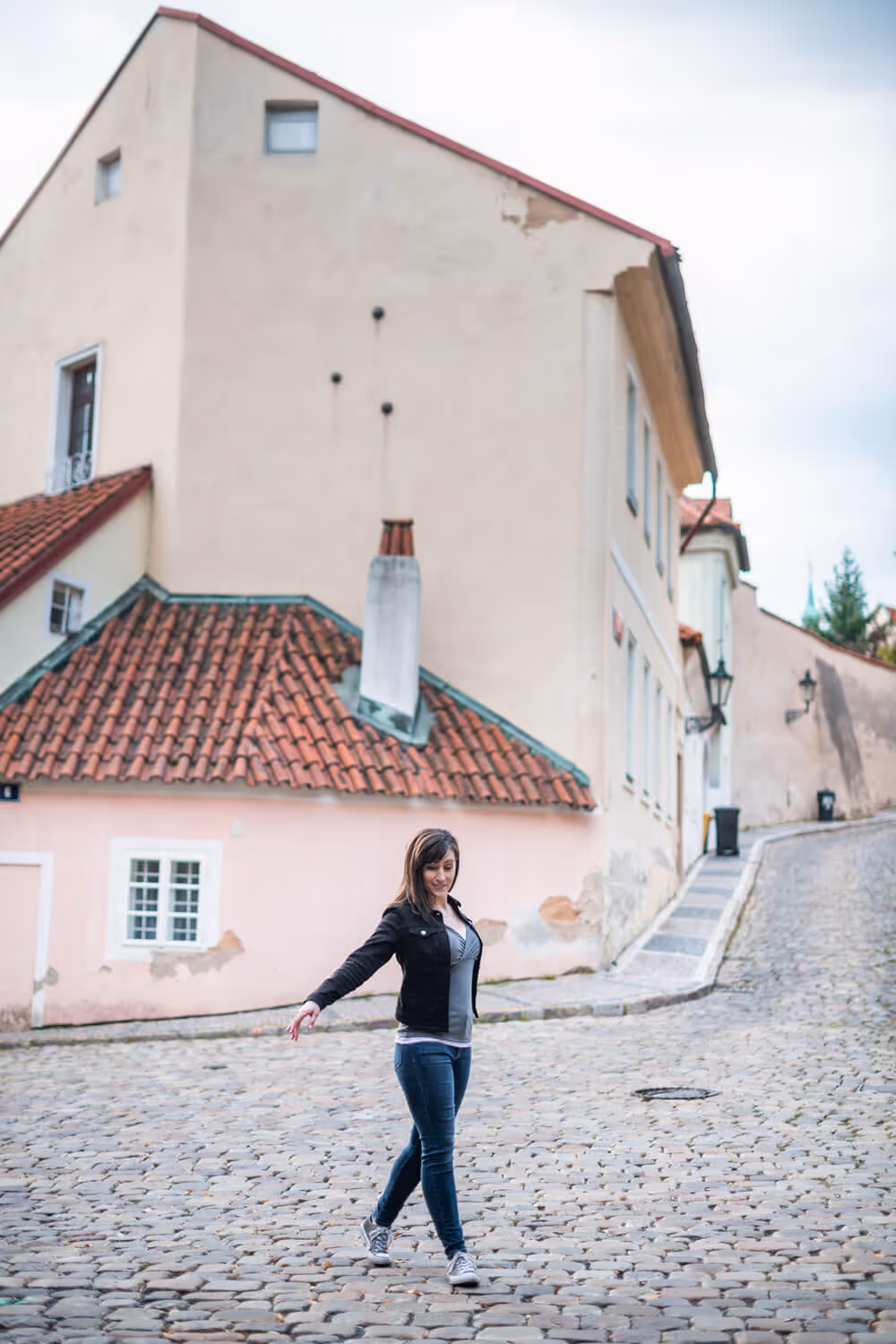 Juliann Beals - A UX Website Designer - twirling around on a cobblestone street with old buildings in the background. 