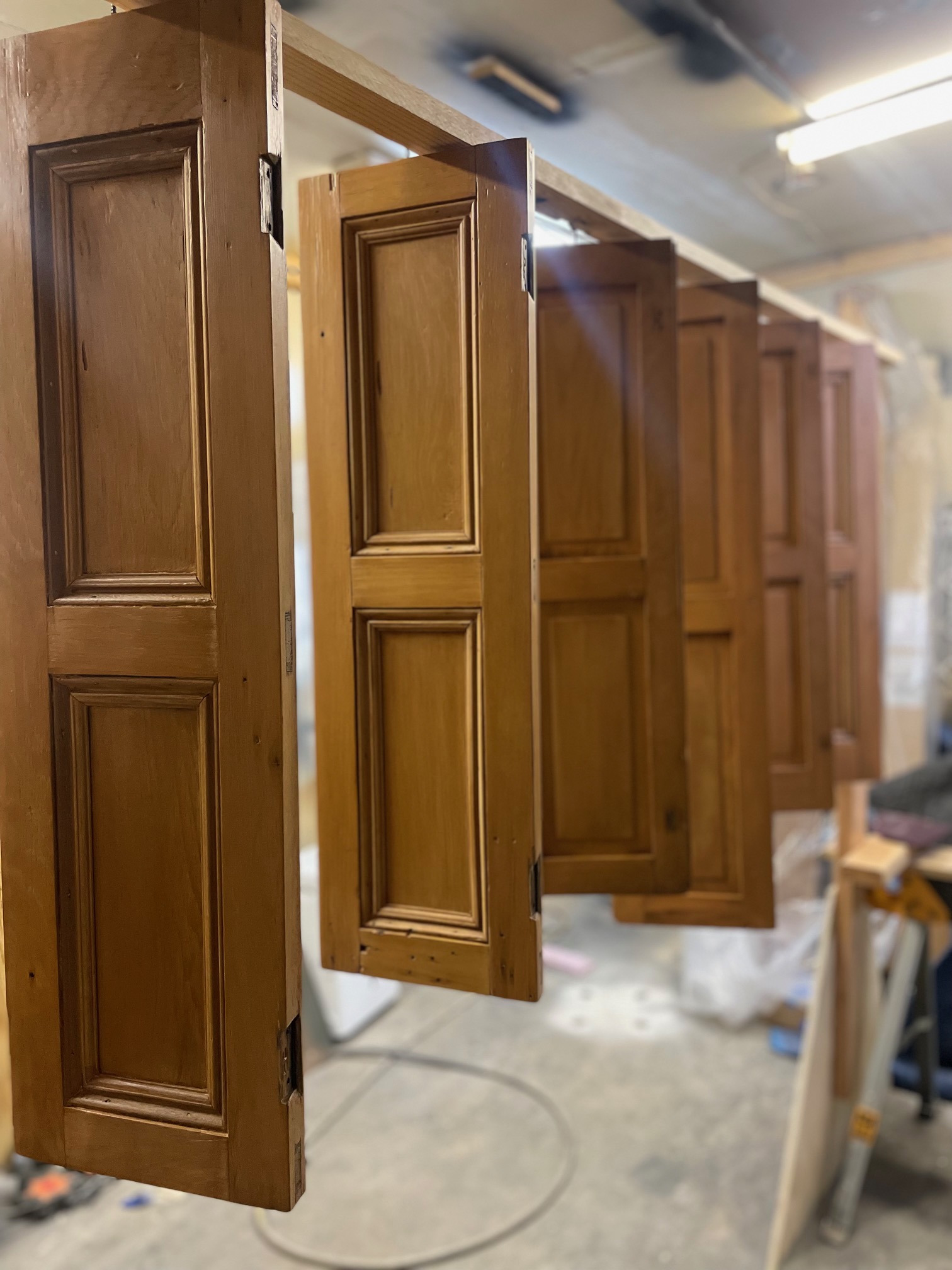 Restored wooden panel doors drying in restoration workshop