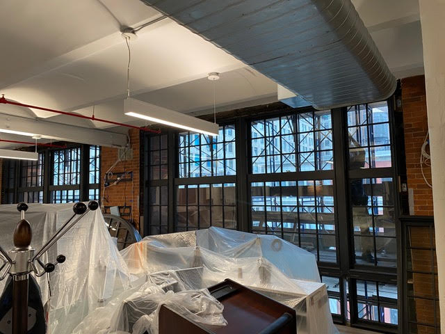Industrial workshop interior with large factory windows and covered equipment