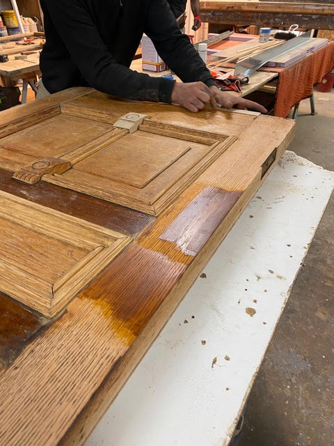 Antique wood door being refinished and stained during restoration process