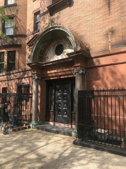 Historic landmark building entrance with arched stone doorway and ornate iron gate