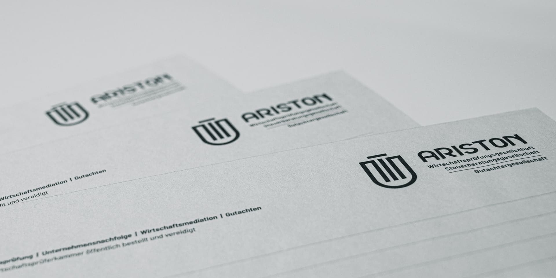 Detailaufnahme von ARISTON-Briefpapier mit Logo und Linien. Fokus liegt auf der hochwertigen Papierstruktur und dem Aufdruck oben.