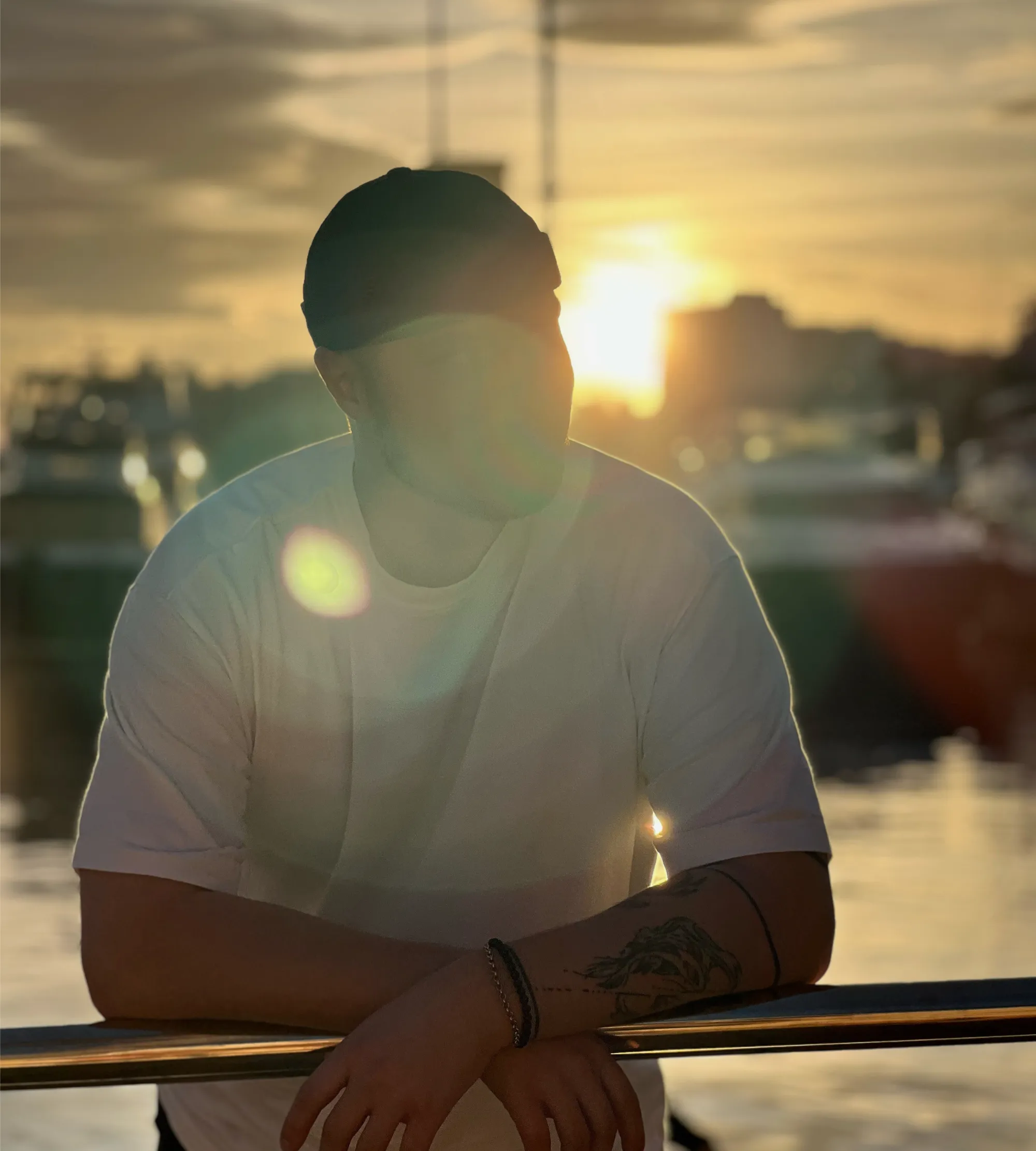 Aatu Junttila nojaamassa kaiteeseen auringonlaskussa 2023.