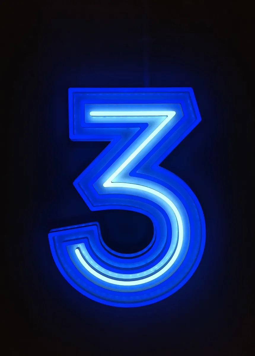 Bright blue neon number 3 glowing against a black background.