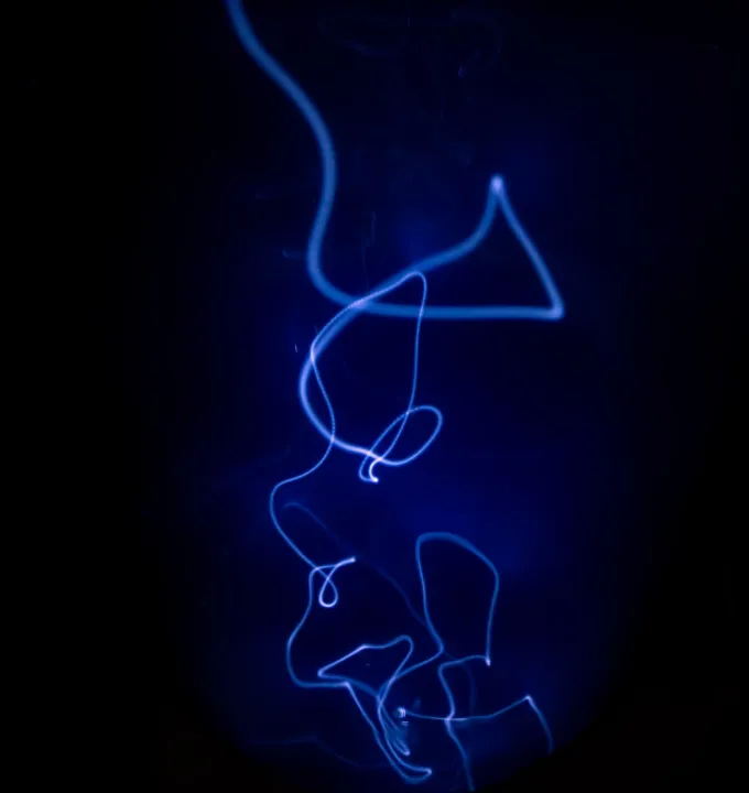Abstract swirling blue light trails on a dark background.