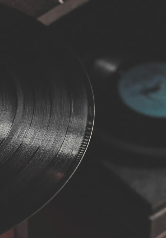 Close-up of a black vinyl record on a turntable with blurred background.