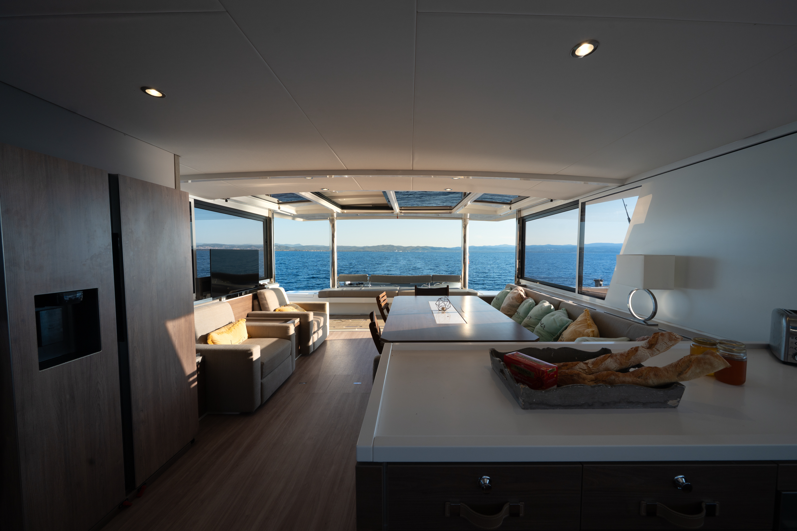 Photographie interieur du catamaran, salon avec ouverture sur la mer