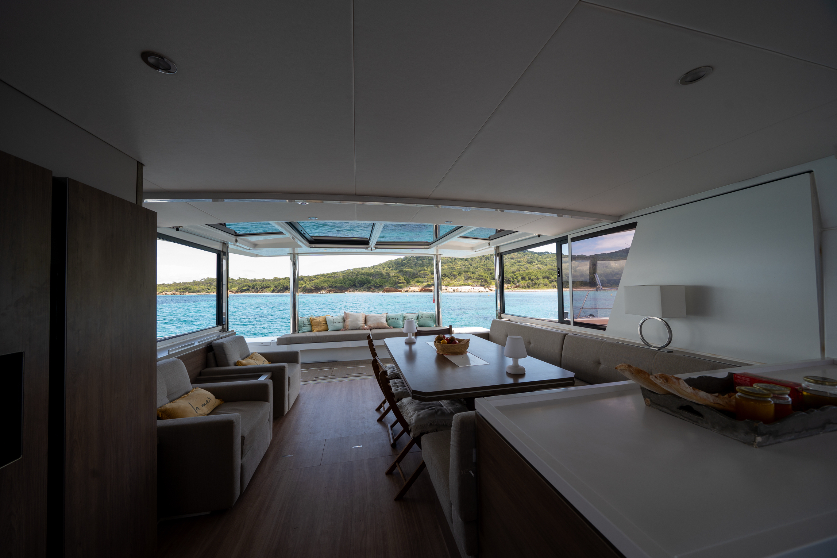 Photo intérieur du bateau, vue de la salle a manger / salon dégagé sur la mer