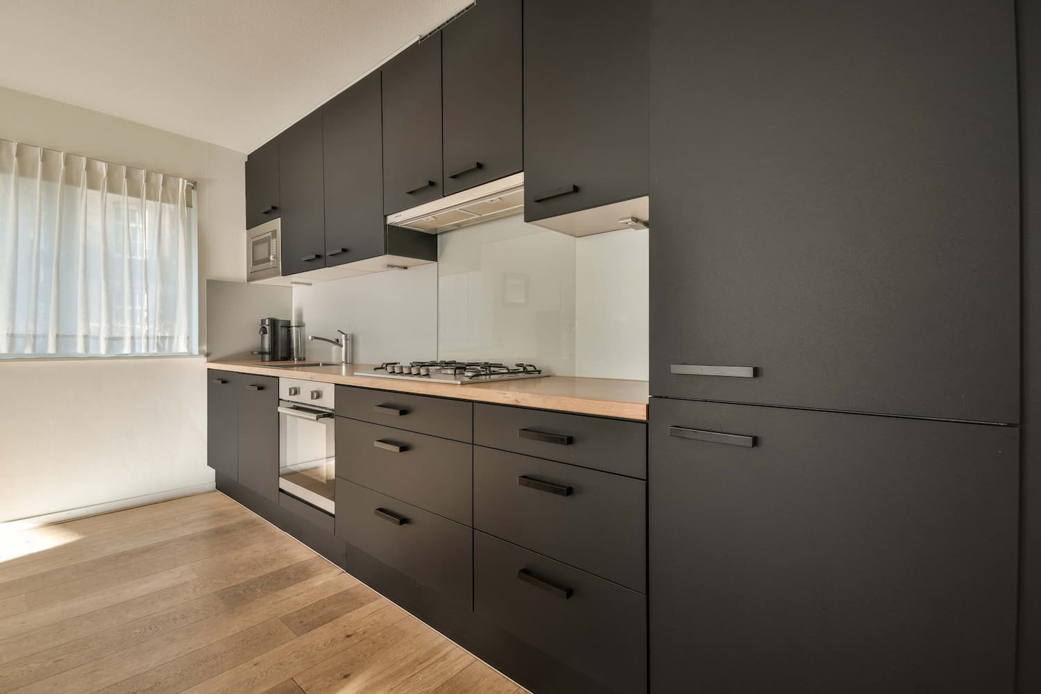 modern kitchen with wooden countertops and sleek black cabinets