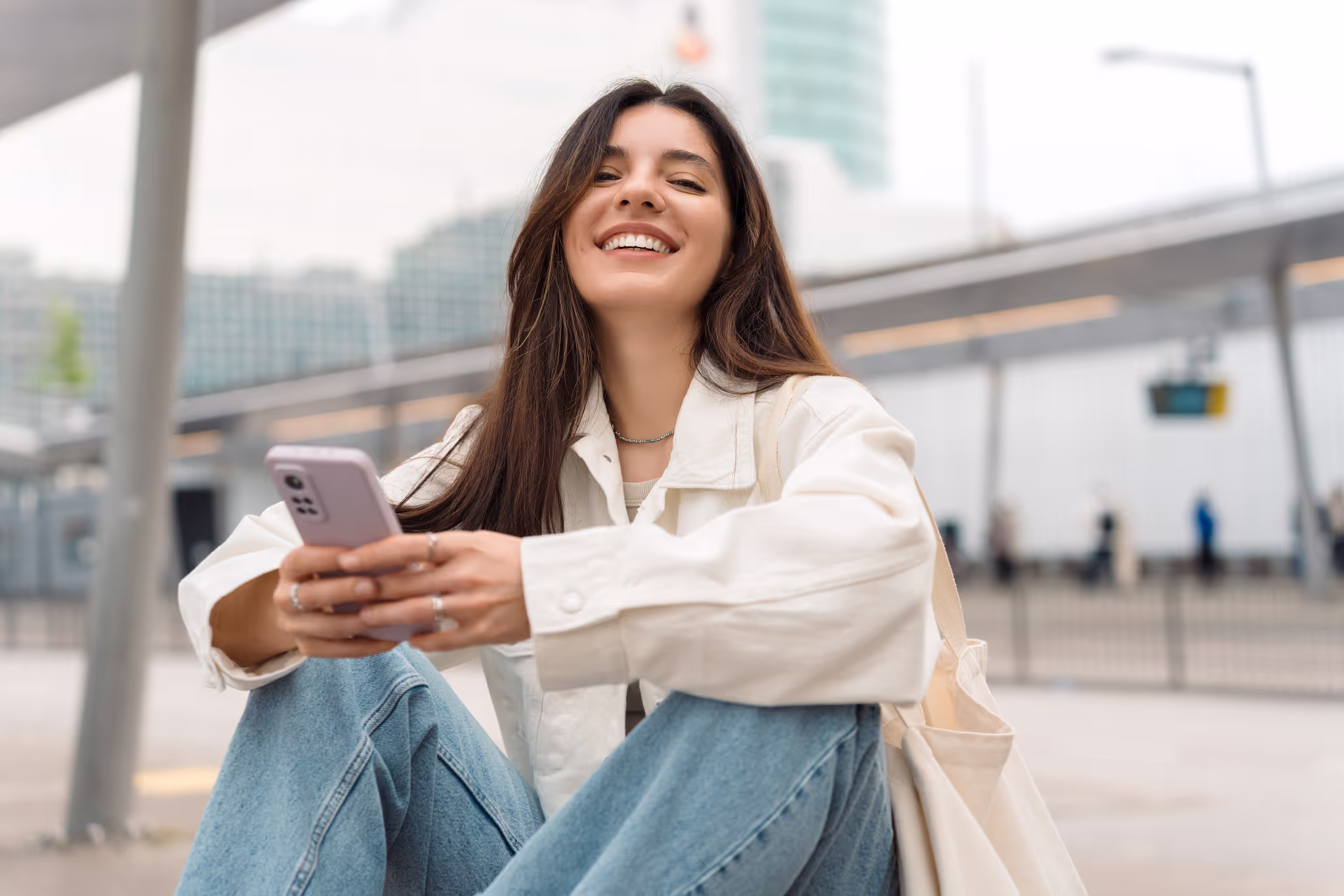 A woman smiling sitting on the streets.