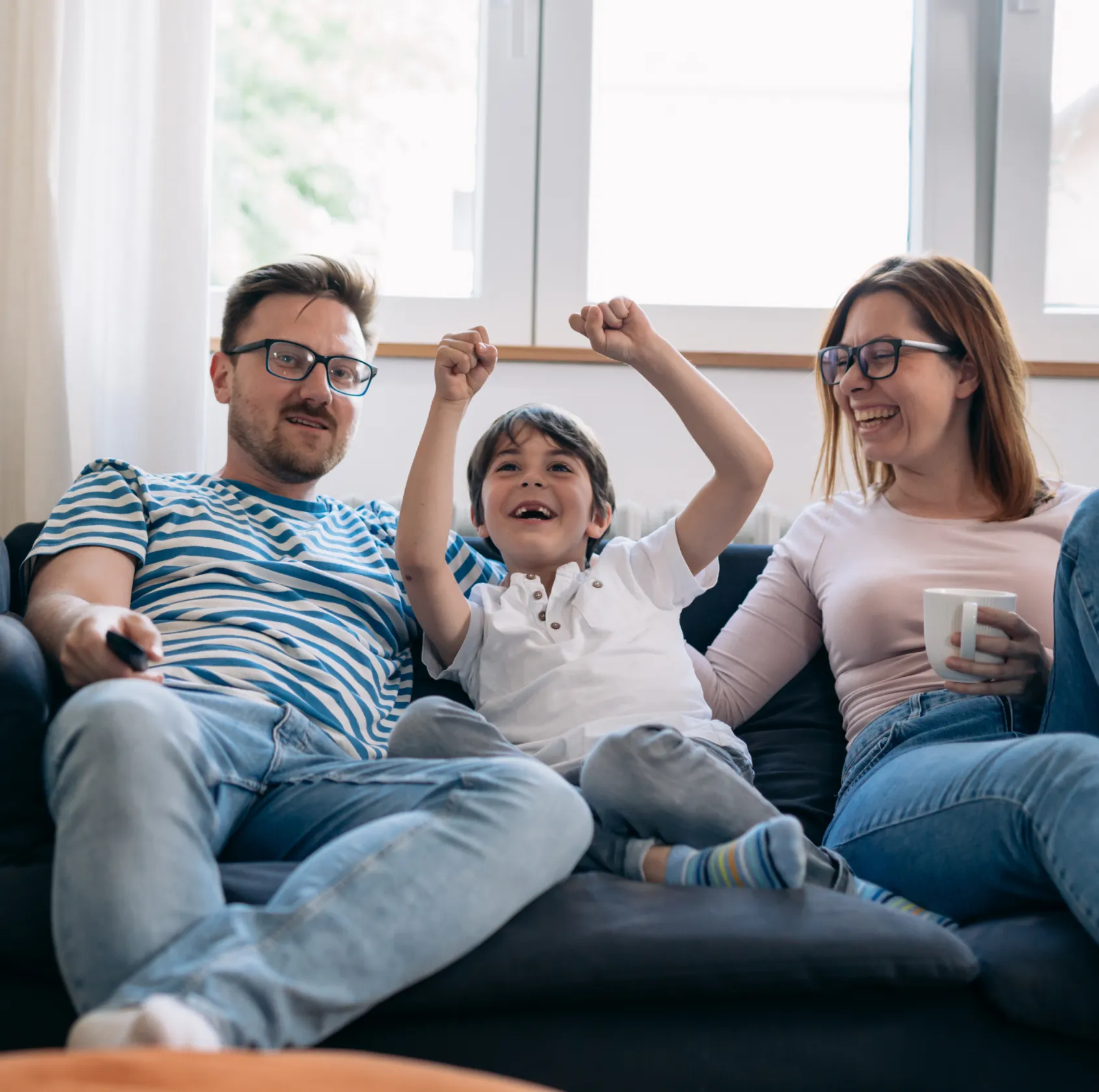 A man, woman and child sitting on a couch.