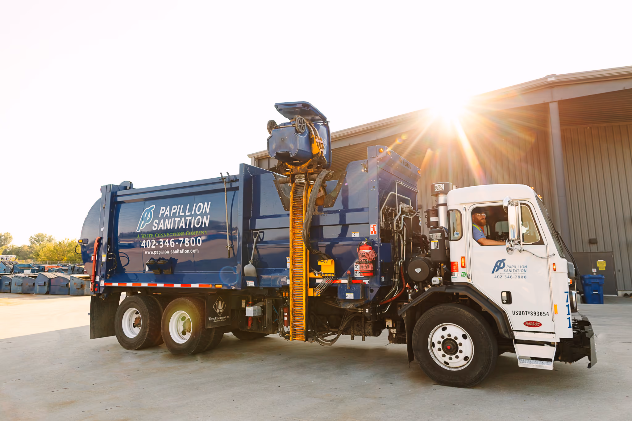 Side-load garbage truck used for residential curbside waste collection