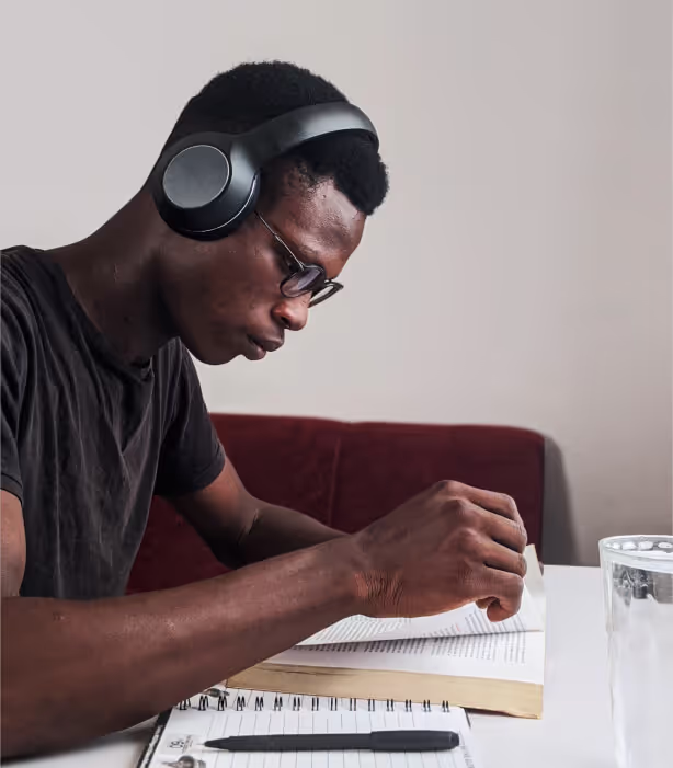 person with headphones looking at his notebook