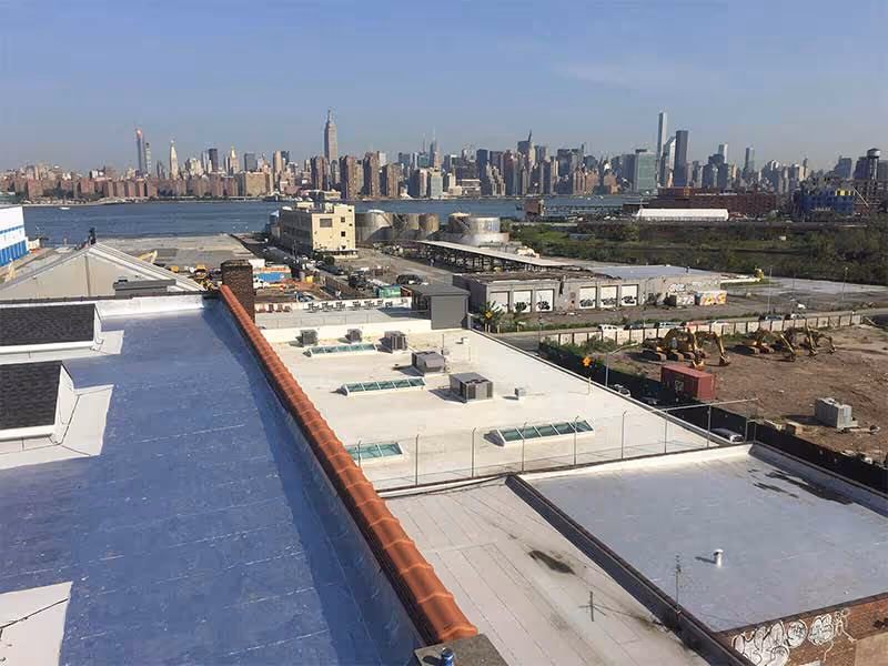 Commercial roofing installation on large industrial building exterior