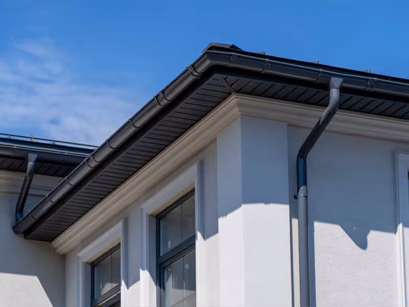 Gutter installation along residential roof edge exterior