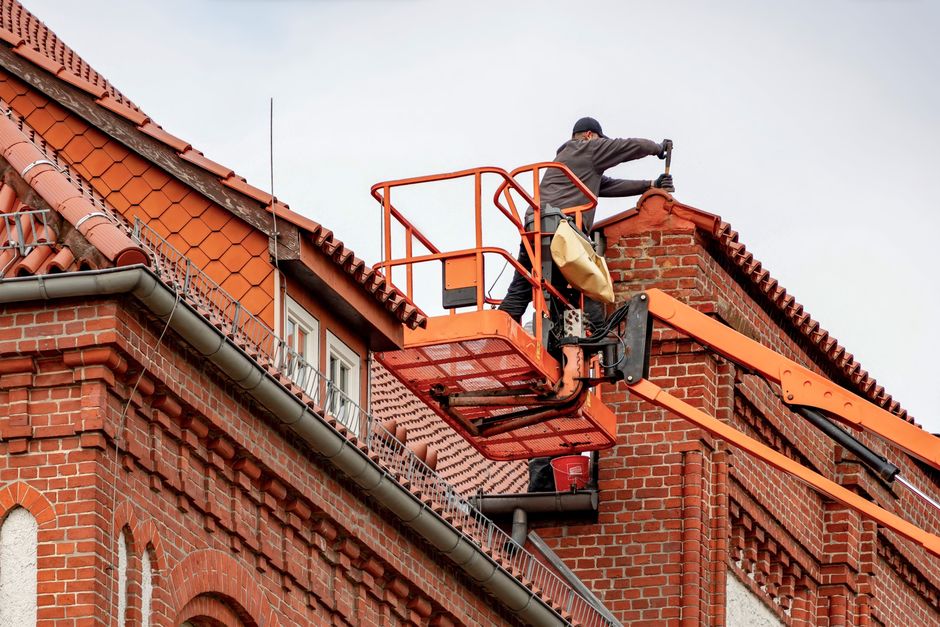professional gutter installers working on a roofline professional gutter installers working on a roofline