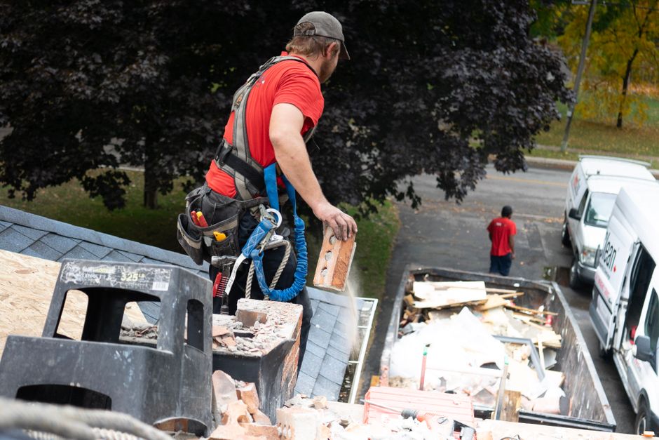 A professional roofing team wearing full safety gear and OSHA-compliant harnesses on a Long Island job site A professional roofing team wearing full safety gear and OSHA-compliant harnesses on a Long Island job site